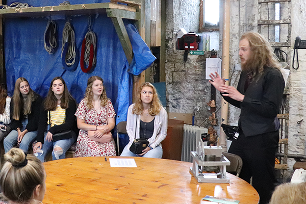 Guide speaks to students in medieval room