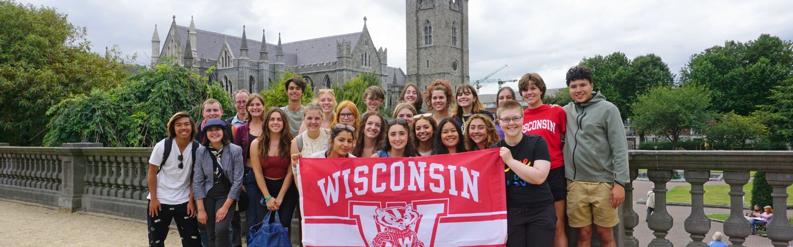 UW Study Abroad Summer Launch students pose in front of St. Patrick's Cathedral and hold UW-Madison flag