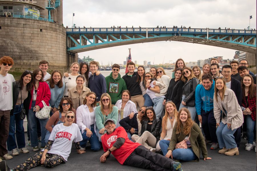 Students pose as a group in front of bridge